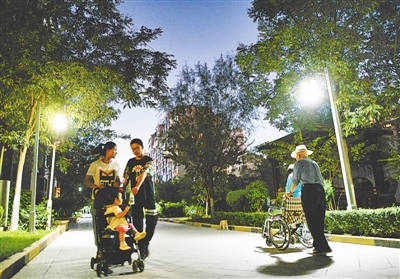<p>　?、嘞﹃?yáng)西下，晚飯后的人們?cè)诃h(huán)境優(yōu)美的小區(qū)中休閑散步。</p>