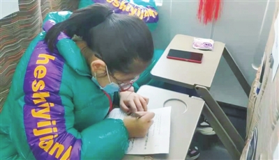     小學(xué)生楊斐在D4350次列車上寫作業(yè)。