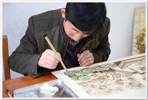 倪建成烙鐵畫(huà)創(chuàng)作中.jpg