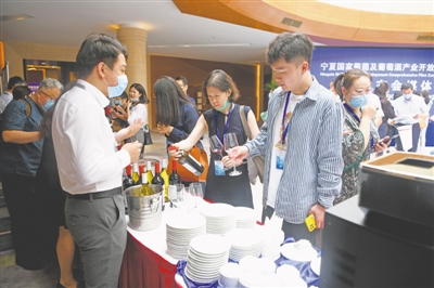 <p>　　參會(huì)嘉賓和記者近距離了解寧夏葡萄酒。</p>