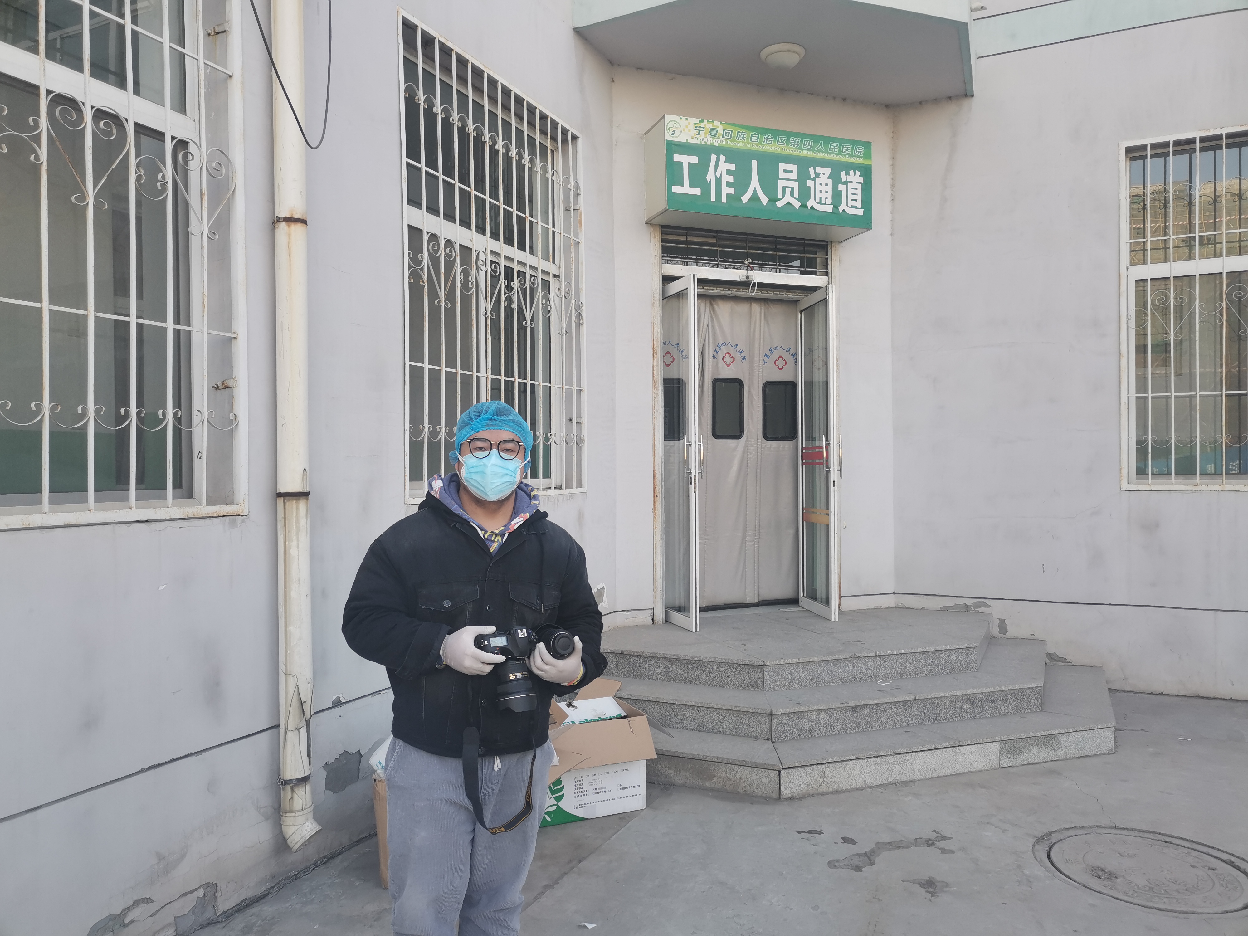 1月27日，寧報(bào)集團(tuán)馬楠在自治區(qū)第四人民醫(yī)院隔離病區(qū)樓門前全副武裝，準(zhǔn)備從工作人員通道進(jìn)入該樓的清潔區(qū)采訪。.jpg