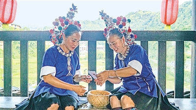     程陽橋上，侗族婦女在展示制作侗族刺繡產(chǎn)品。繡品圖案精美、色彩艷麗，成為當?shù)靥厣a(chǎn)業(yè)。